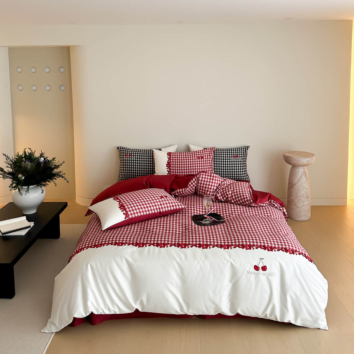 Bed with red and white checkered bedding in a modern bedroom setting.