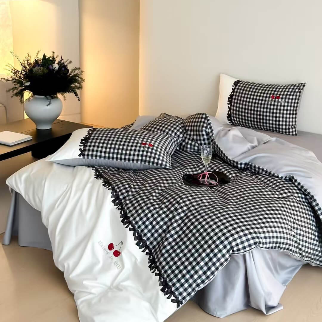 Bed with black and white checkered bedding in a bedroom setting.