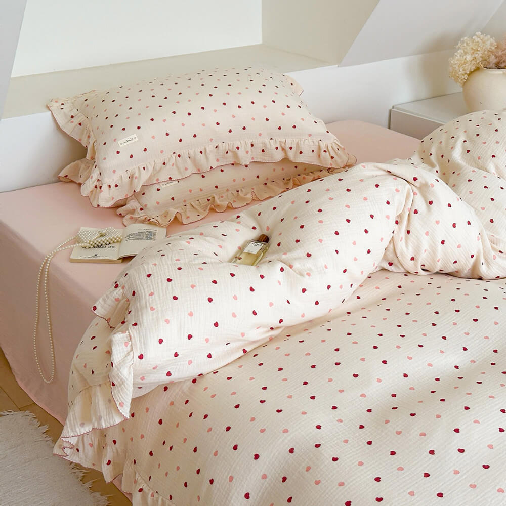 Detailed shot of a pink heart duvet cover set with ruffles, showcasing the subtle pattern and soft texture