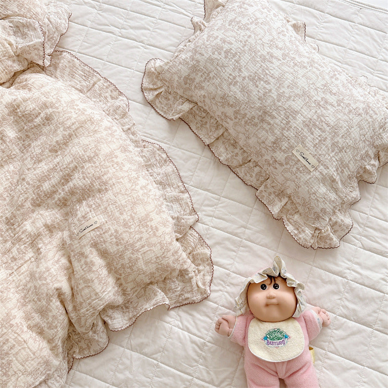 Cotton muslin ruffle duvet cover set with woodland animal print and brown trim, folded on bed