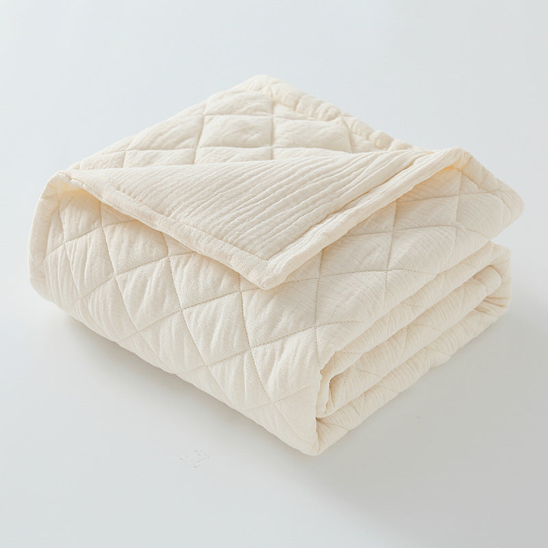 Ivory cotton muslin baby quilt folded showing soft, breathable double-layer gauze texture