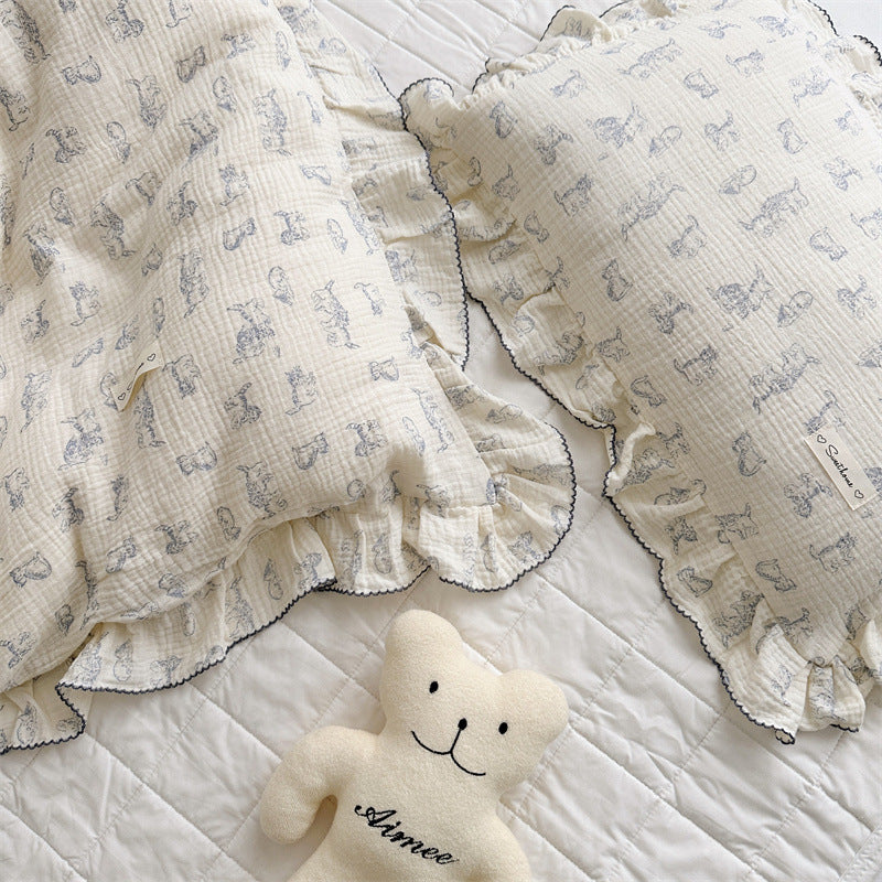 Kitty print ruffle duvet cover set with blue trim in soft cotton muslin, styled with plush bear