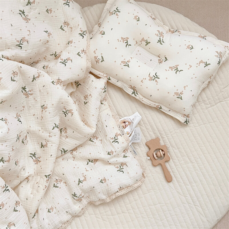 Cotton muslin comforter with floral print and lace trim on toddler crib