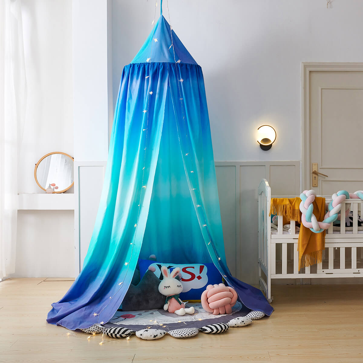 Blue gradient kids' bed canopy set up as a play tent on the floor with toys inside.