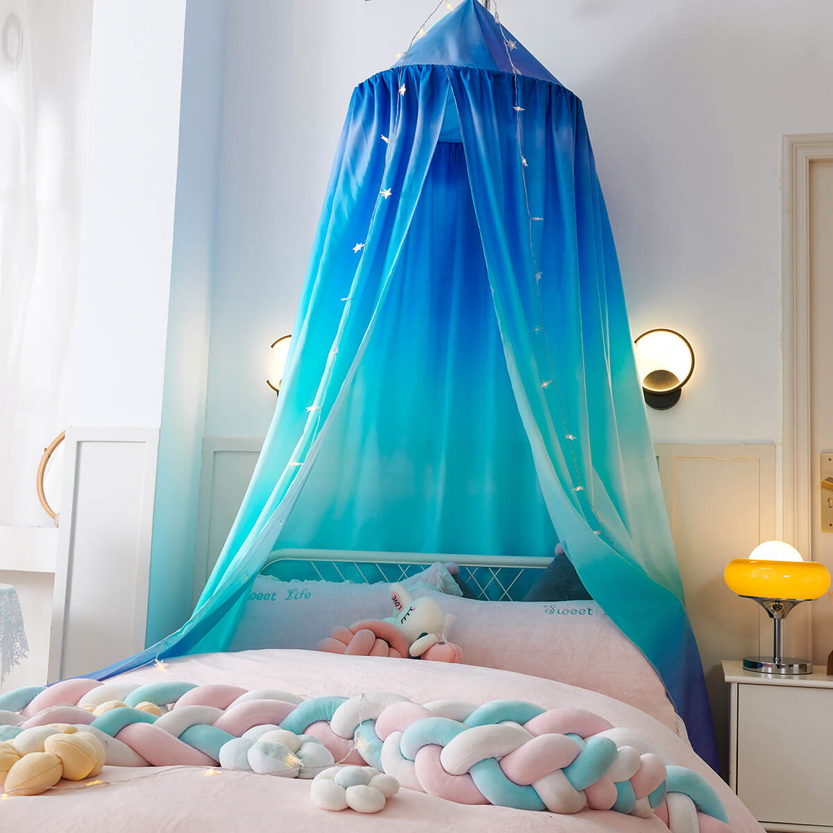 Blue ombre dome canopy with a star print over a pink and white bed.
