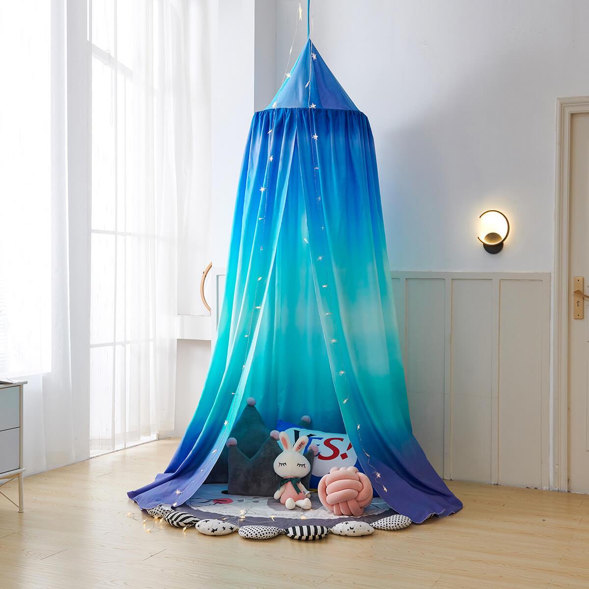 A blue ombre kids' bed canopy arranged as a cozy play tent for boys, with pillows and toys.