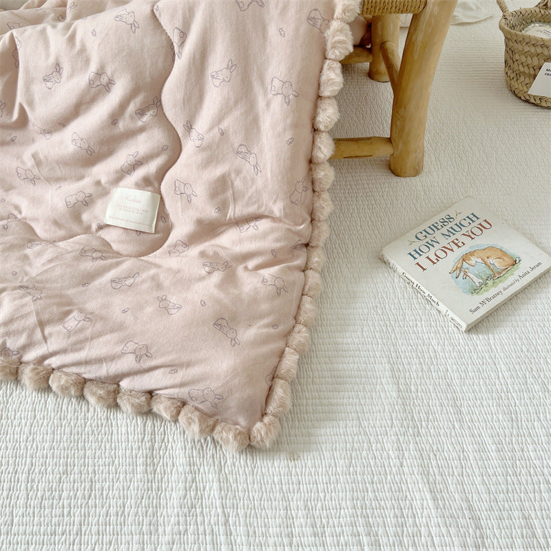 Khaki textured quilt with a book on a light surface