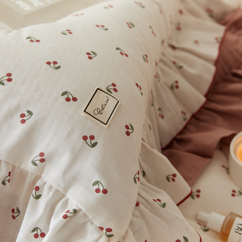 A closed-up cherry-print cotton pillowcase, displaying the soft, lightweight fabric texture.