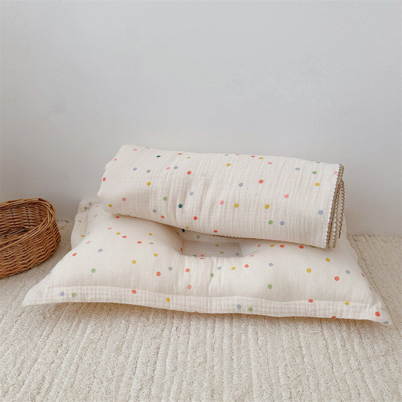 A clean, horizontal lay of the folded Colorful Dot muslin blanket and pillow, showing the full set against a neutral background. This angle highlights the product's shape and design.