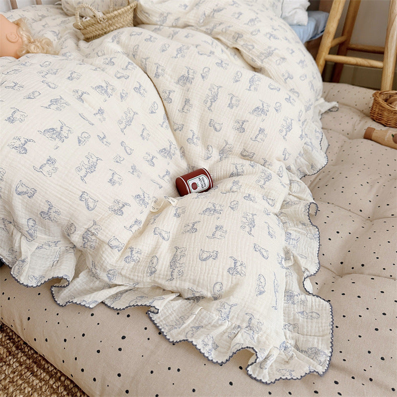 Lamb print ruffle duvet cover in cream cotton muslin, displayed on a dotted beige mattress, playful children’s decor