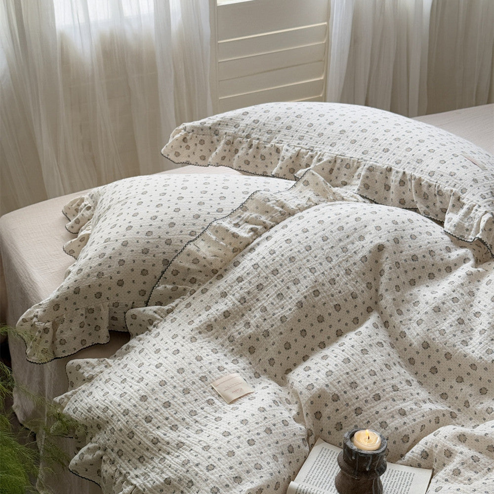 A close-up of the elegant ruffled pillowcases and duvet cover from the cotton muslin set.