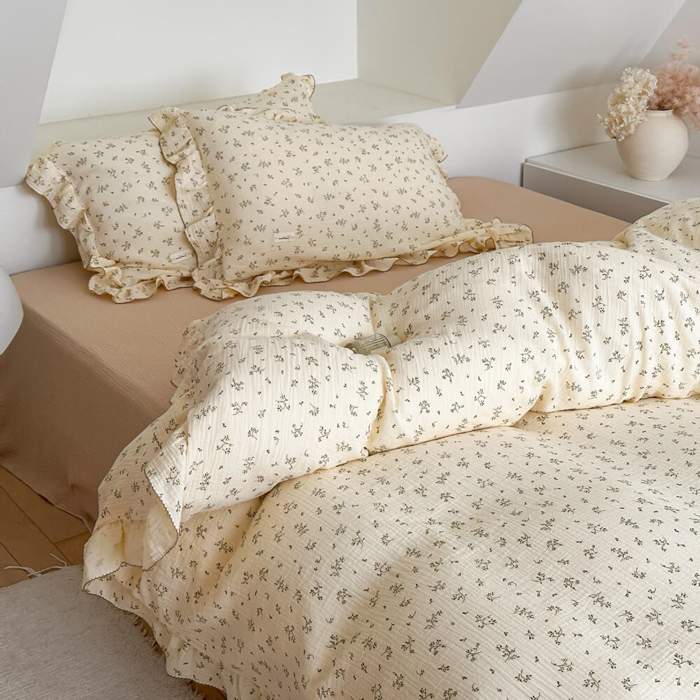 Sand-colored flat sheet paired with olive green floral cotton muslin duvet cover
