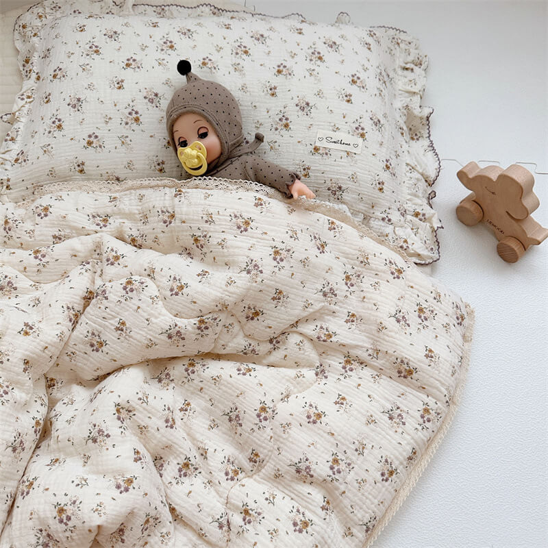 Soft cotton muslin baby quilt in a delicate violet floral print and ruffled pillowcase