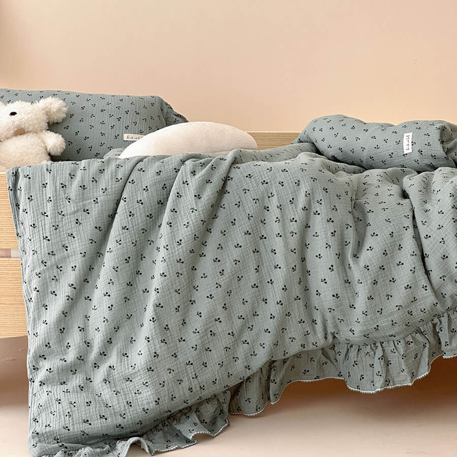Close-up shot of the sage floral cotton gauze bedding set for kids, highlighting the soft texture and tiny floral pattern on the duvet cover.