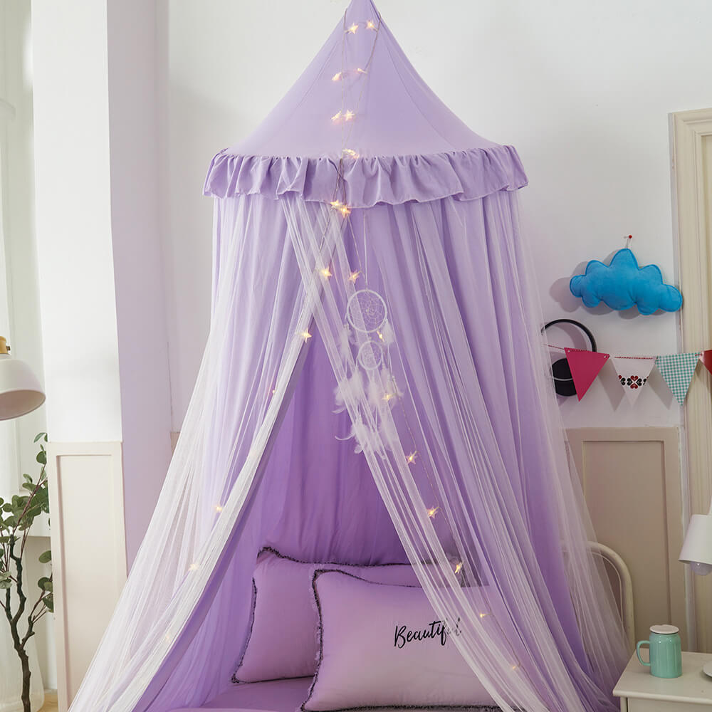 Front view of a purple double-layer kids bed canopy over a bed, with pillows and a dreamcatcher hanging from the top