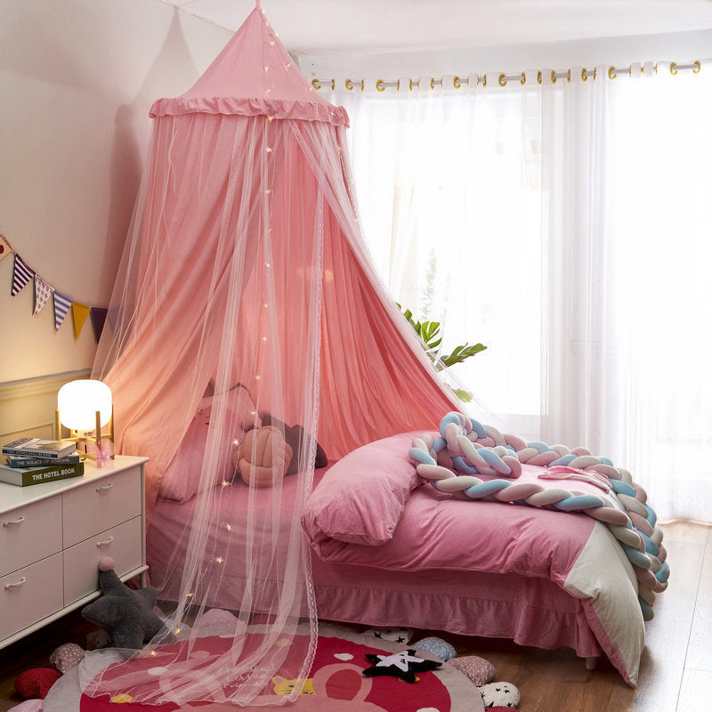 Pink double-layer kids bed canopy with sheer mesh and string lights, creating a soft and cozy atmosphere for a child's bed.