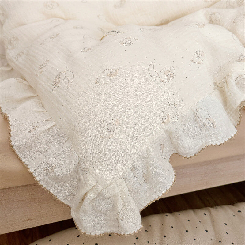 Close-up of cream cotton muslin duvet cover with gentle ruffle trim and minimalist animal print