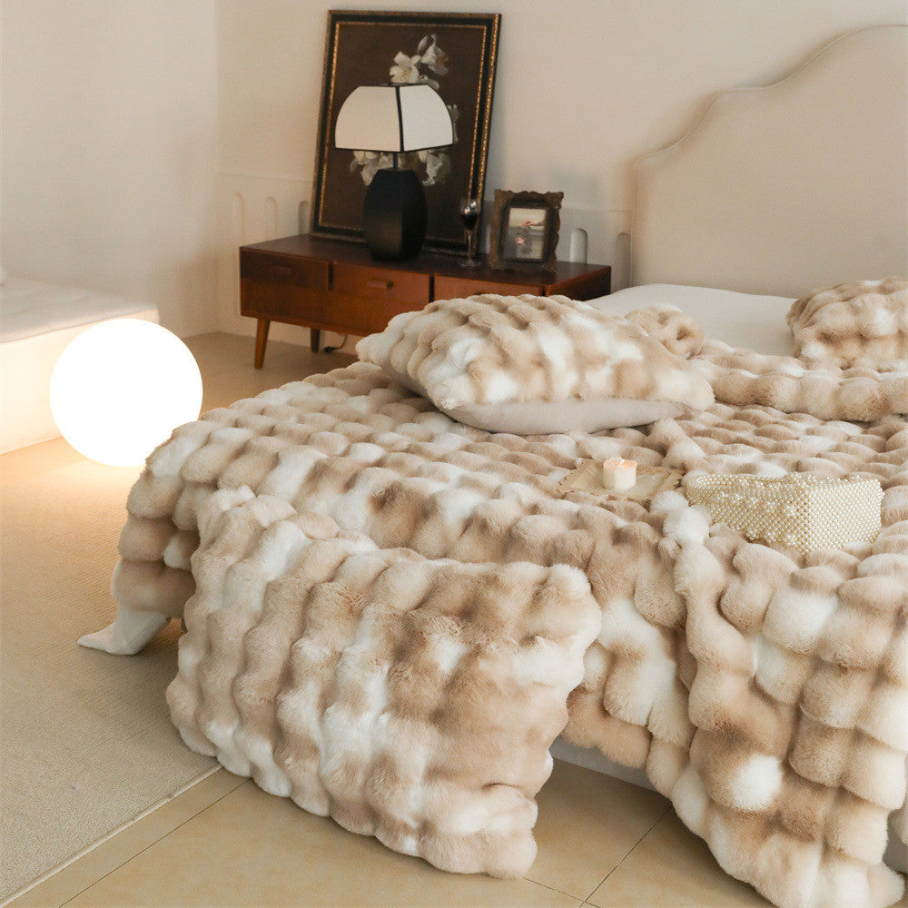 Cozy bedroom scene with a beige and white patterned fluffy faux rabbit fur blanket on a bed