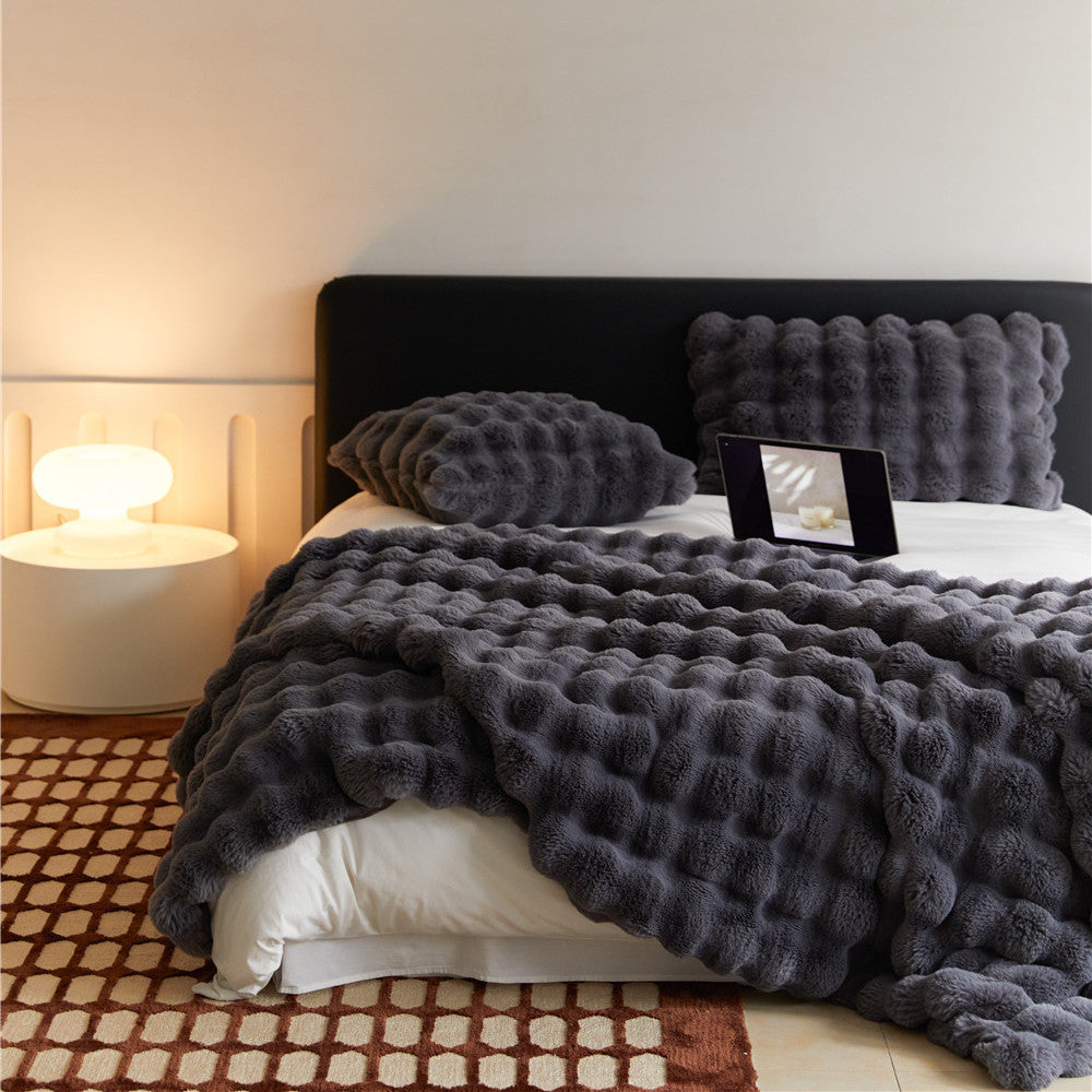 Soft Charcoal textured faux rabbit fur blanket and pillows on a bed