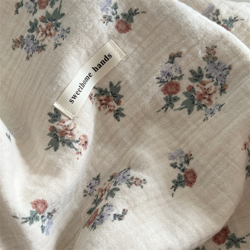 A detailed shot of the Vintage Floral muslin blanket, emphasizing its delicate floral print and the soft, textured fabric.