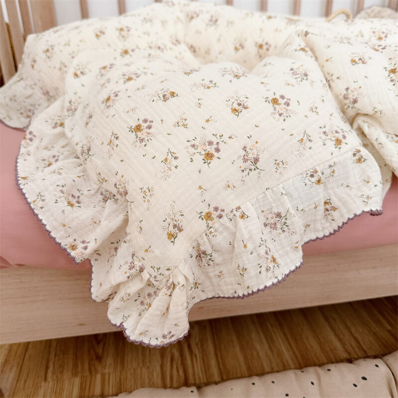 Close-up of duvet cover with ruffled edge and delicate violet floral print in cotton muslin