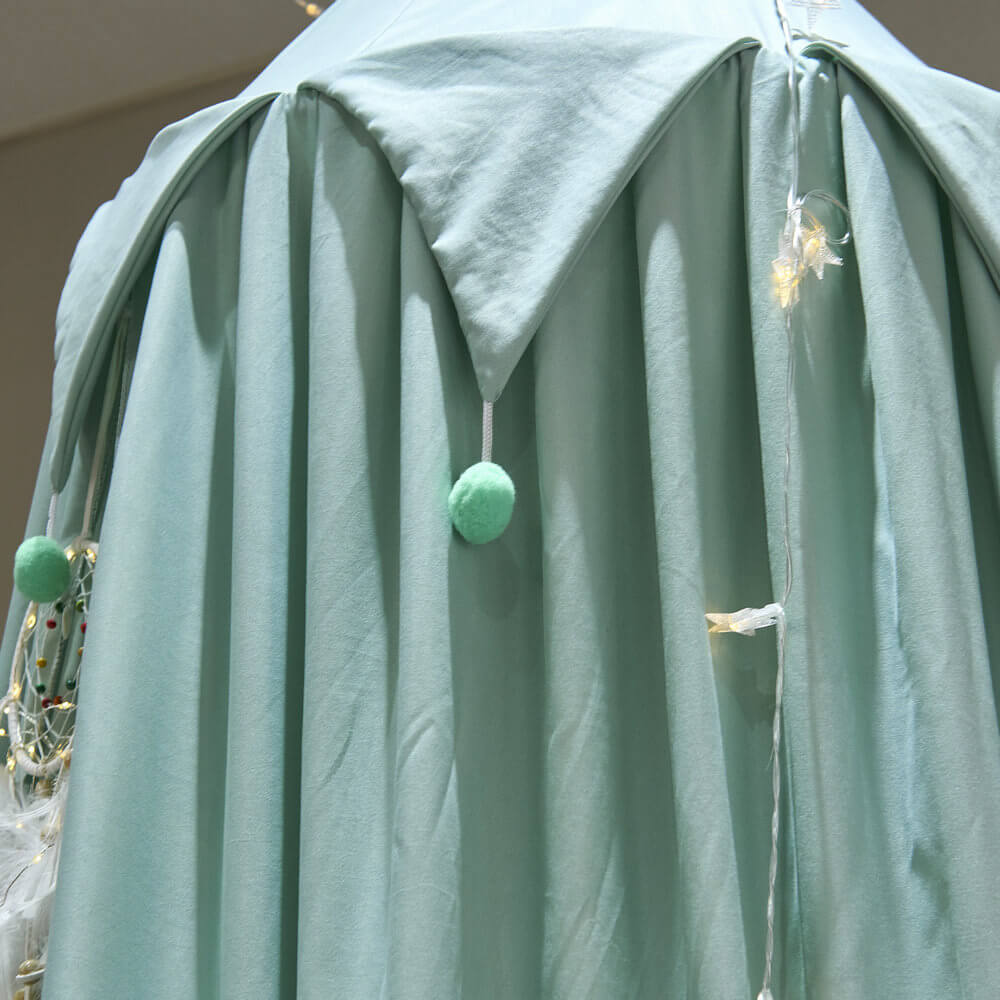 Detail shot of the triangular ruffle and light green pom-poms on the kids bed canopy.
