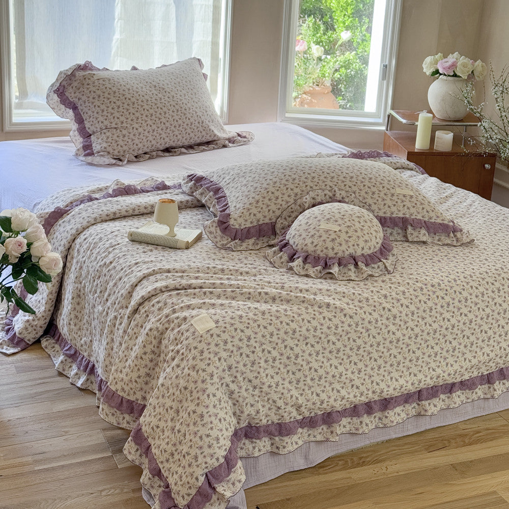 Romantic floral bedding styled with ruffles, round pillow and pastel tones