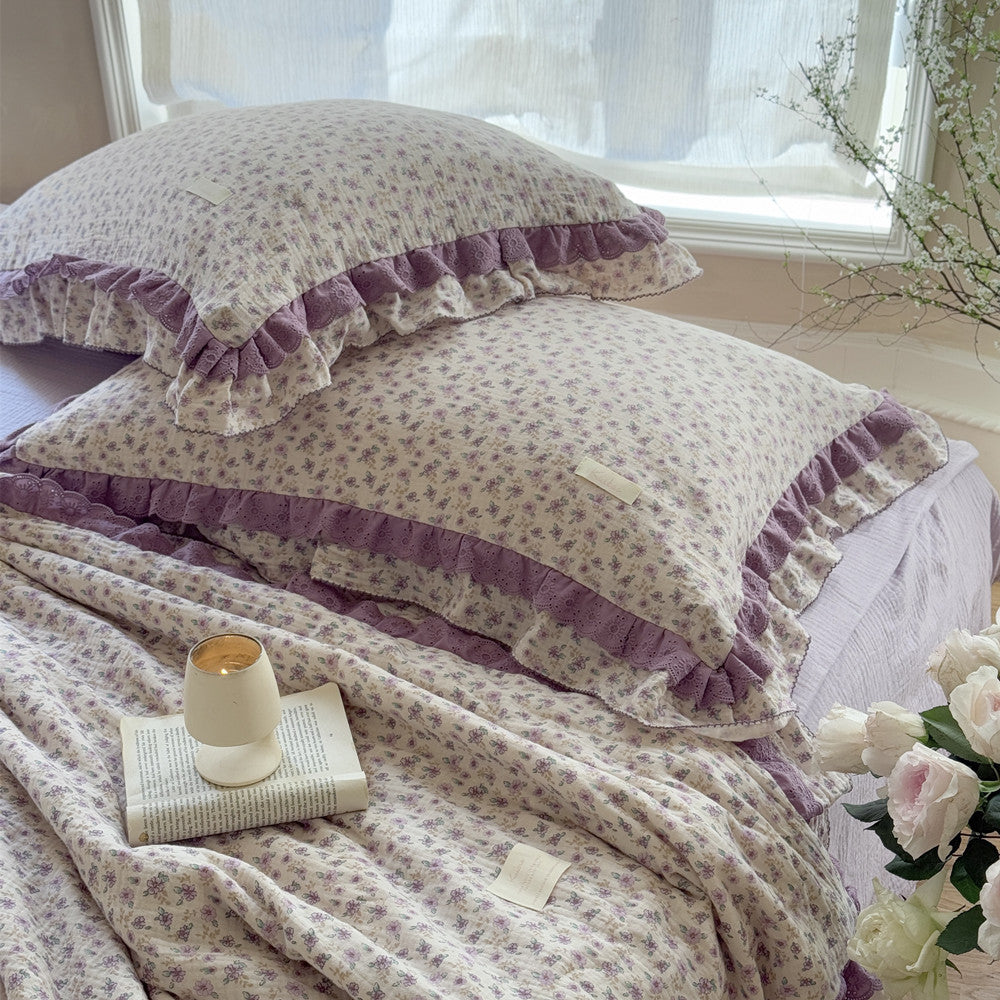 Floral comforter with open book and candle, styled in a girls’ pastel room