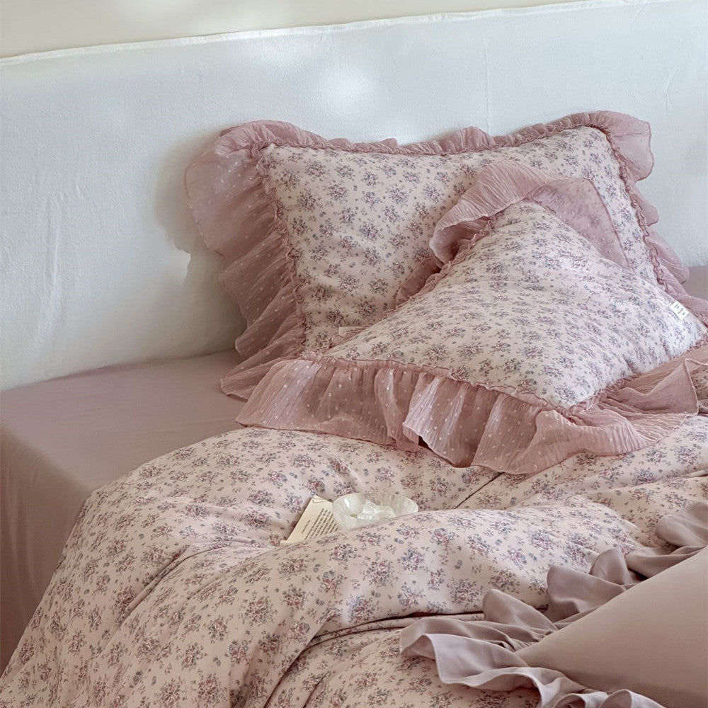 Top-down close-up of the Lavender Floral Duvet Cover and two ruffled pillows, demonstrating the overall small floral print and the smooth, layered appearance of the chiffon trim.