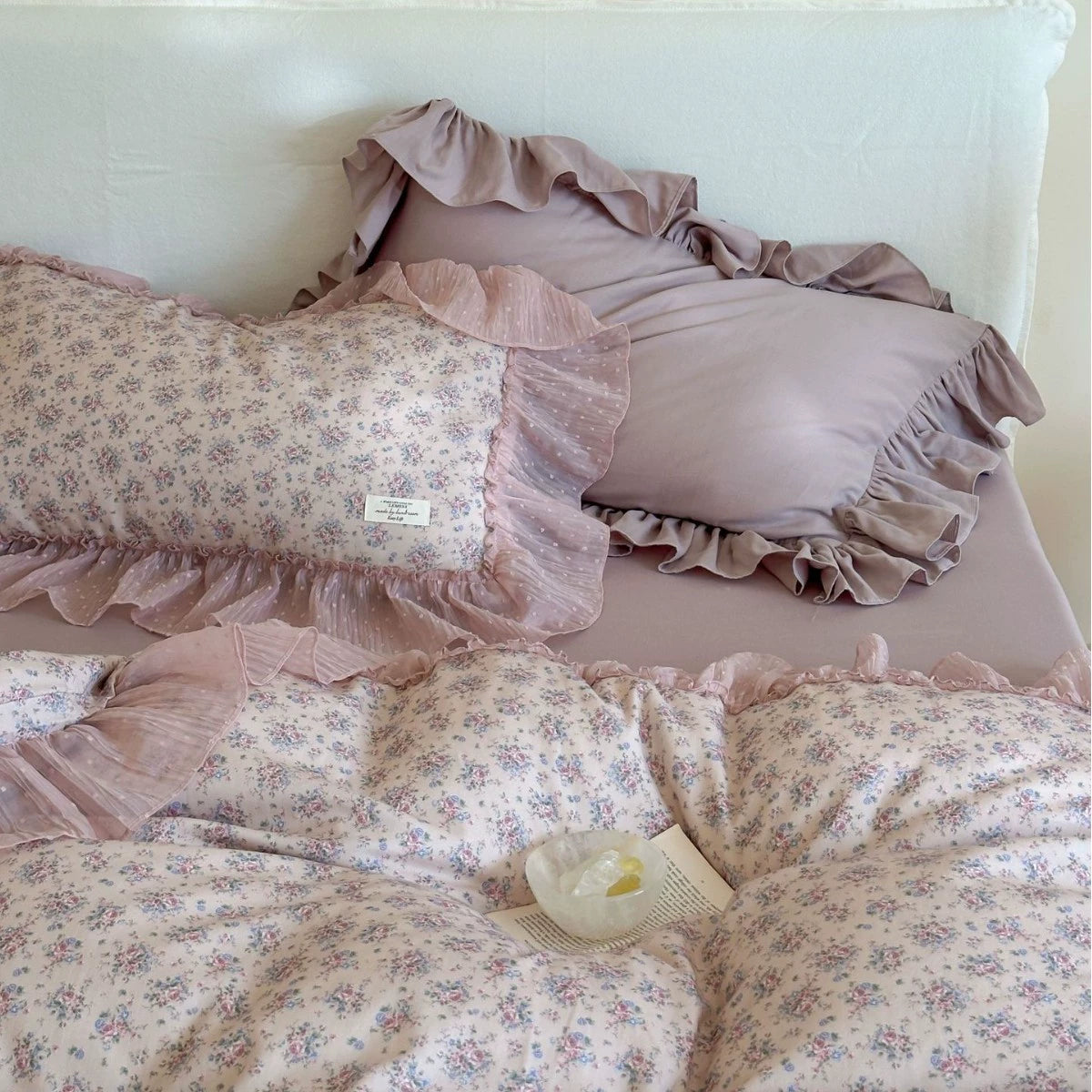 Close-up of the floral and solid mauve pillows from the Lavender Floral Bedding Set, highlighting the sheer, polka-dot chiffon ruffled edges and soft gauze fabric.