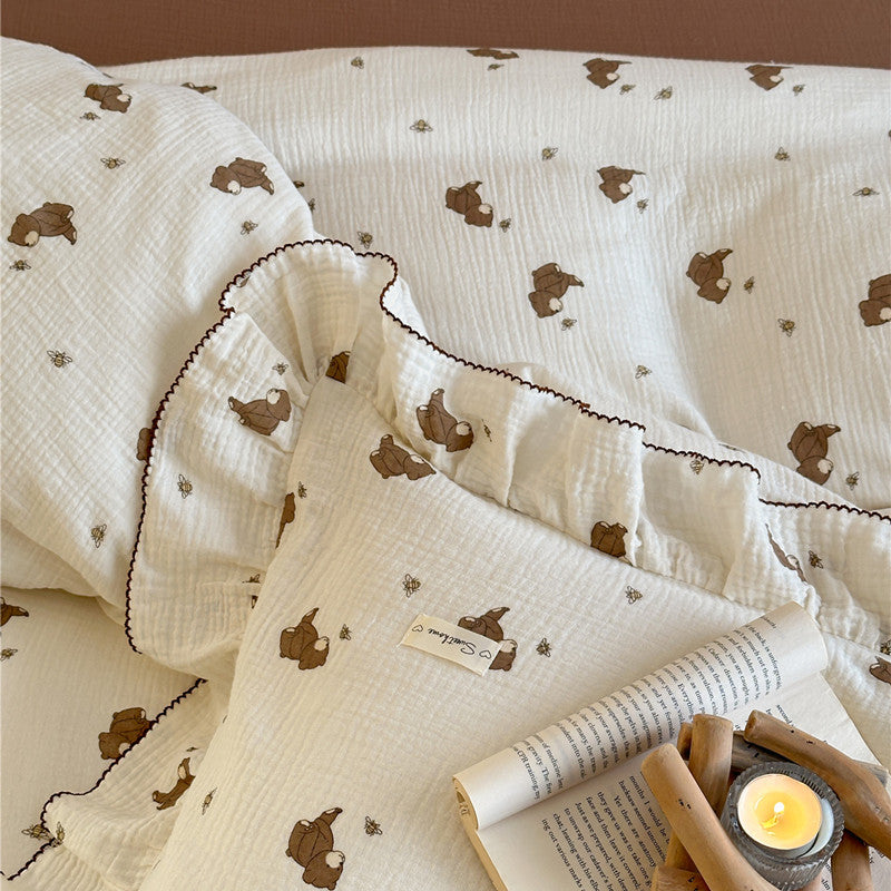 Close-up of bear and bee print muslin duvet cover with ruffled trim