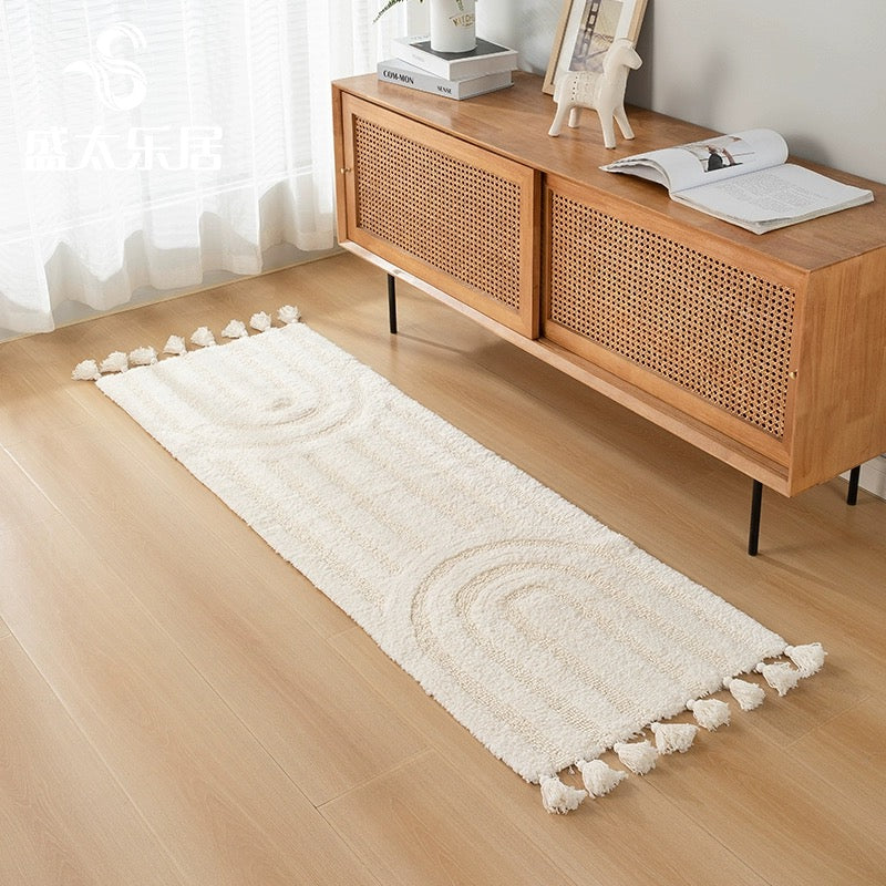 Minimalist rainbow handmade cotton tassel runner rug in ivory color, styled in a minimalist home decor setting.