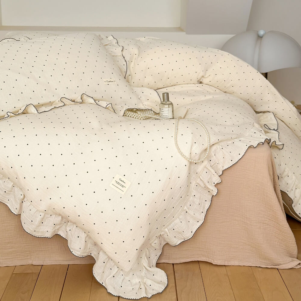 cotton muslin bedding set with ruffled polka dot duvet cover and pillowcases in a cozy minimalist bedroom