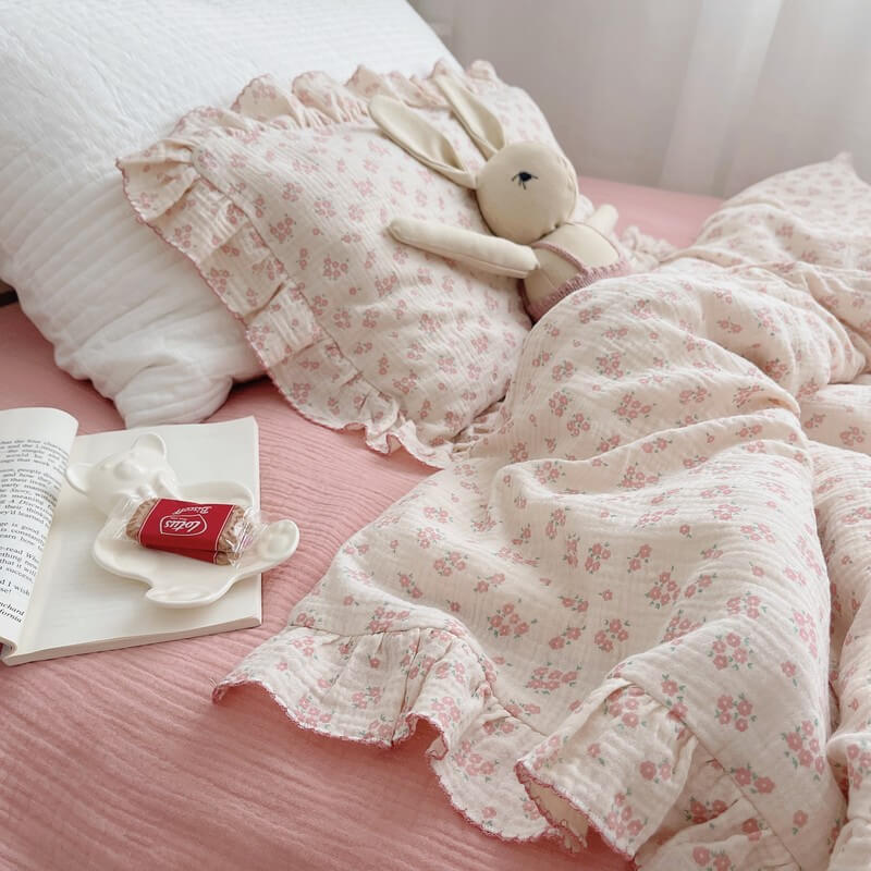 Carmine floral ruffle duvet cover set with dusty pink fitted sheet and plush bunny on bed