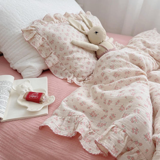Carmine floral ruffle duvet cover set with dusty pink fitted sheet and plush bunny on bed