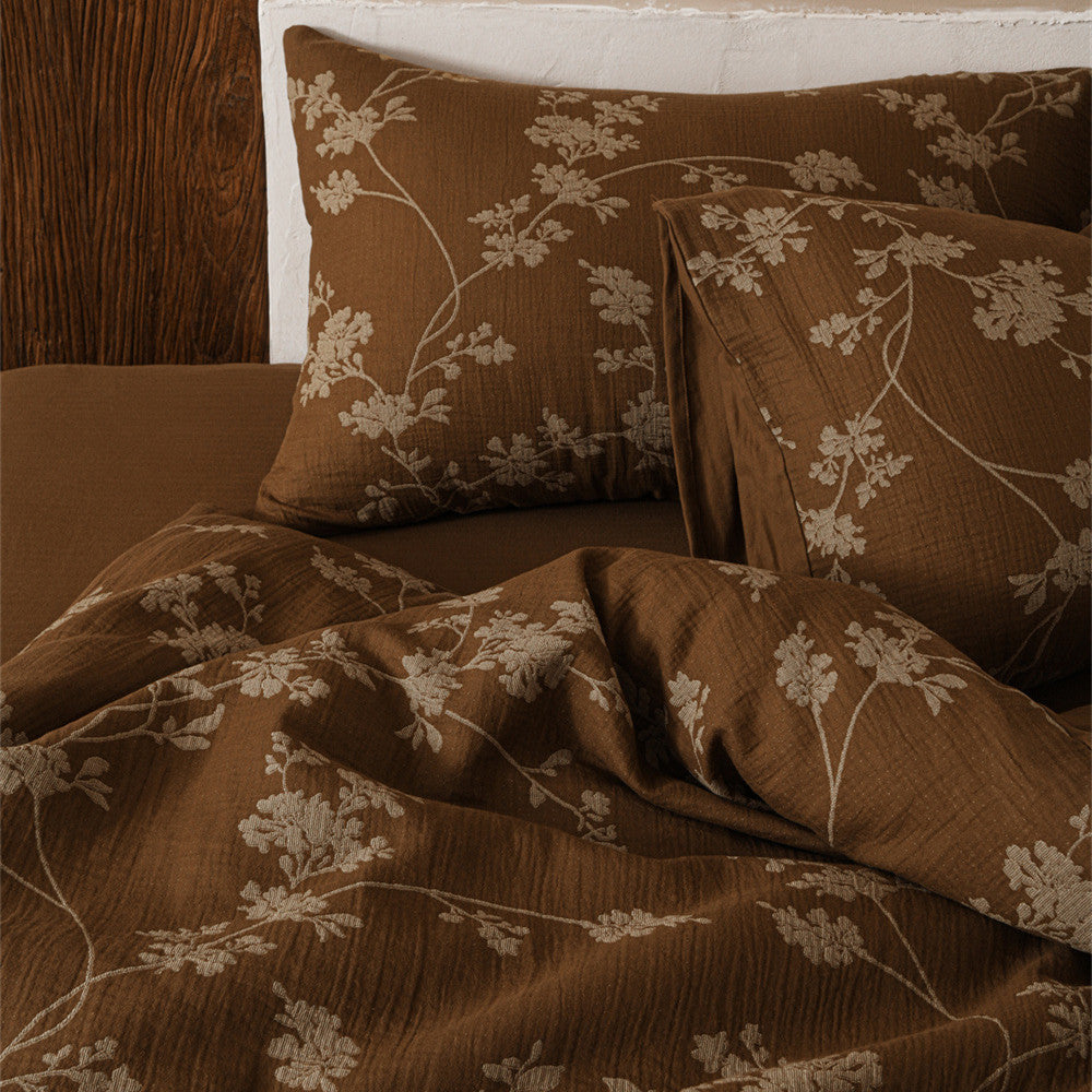 A detailed shot of the brown floral cotton gauze bedding, focusing on the soft, crinkled texture of the fabric and the subtle floral print.
