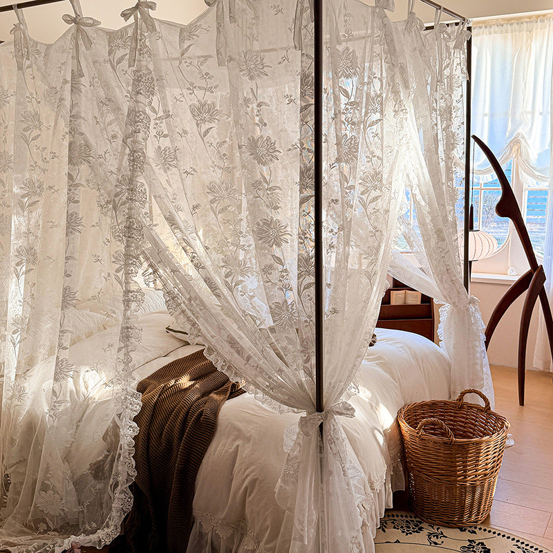 Sheer floral curtains in a bedroom setting with a bed and basket.