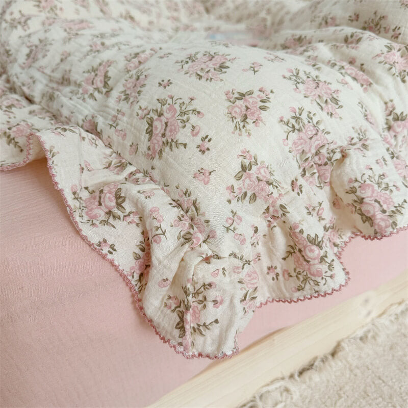 Close-up of pink rose ruffle bedding fabric with scalloped pink stitching