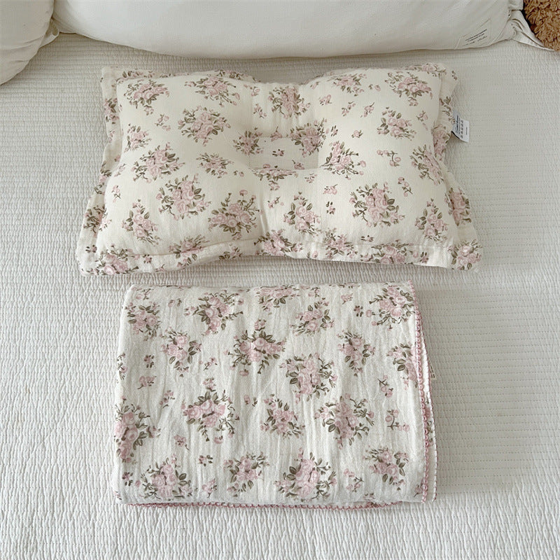 Rosebud pink floral baby pillow and matching muslin blanket set on white bedding