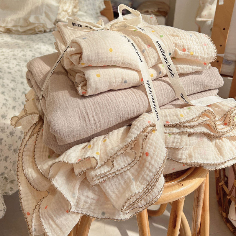 Folded cotton muslin bedding set with pastel dot print and ruffle details