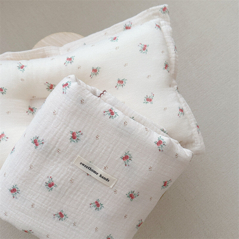 A Toddler blanket and pillow set for sale from the Tiny Rose collection, featuring a gentle floral pattern on a cotton muslin fabric.