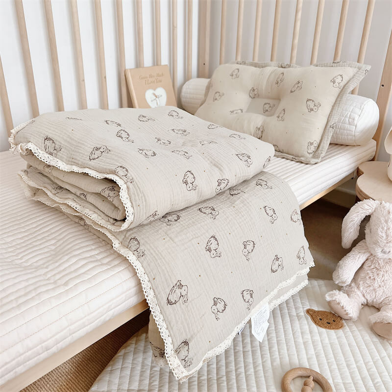 Beige bunny print cotton muslin comforter and pillow styled in a toddler bed