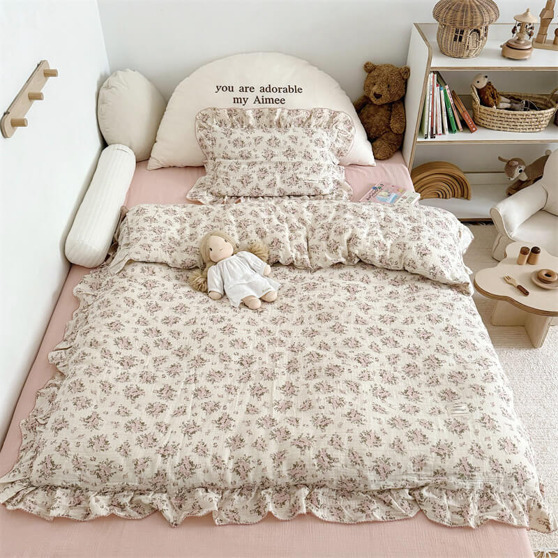 Cozy pink floral bedding on a wooden bed with pink flat sheet