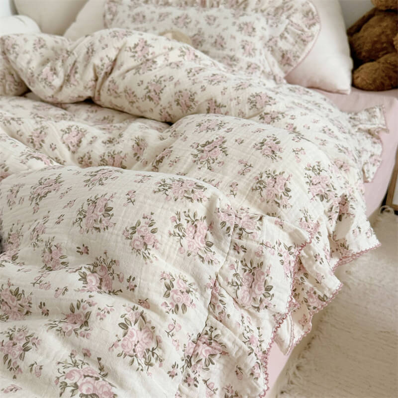 Side angle of cotton gauze bedding with pink rose clusters and ruffles