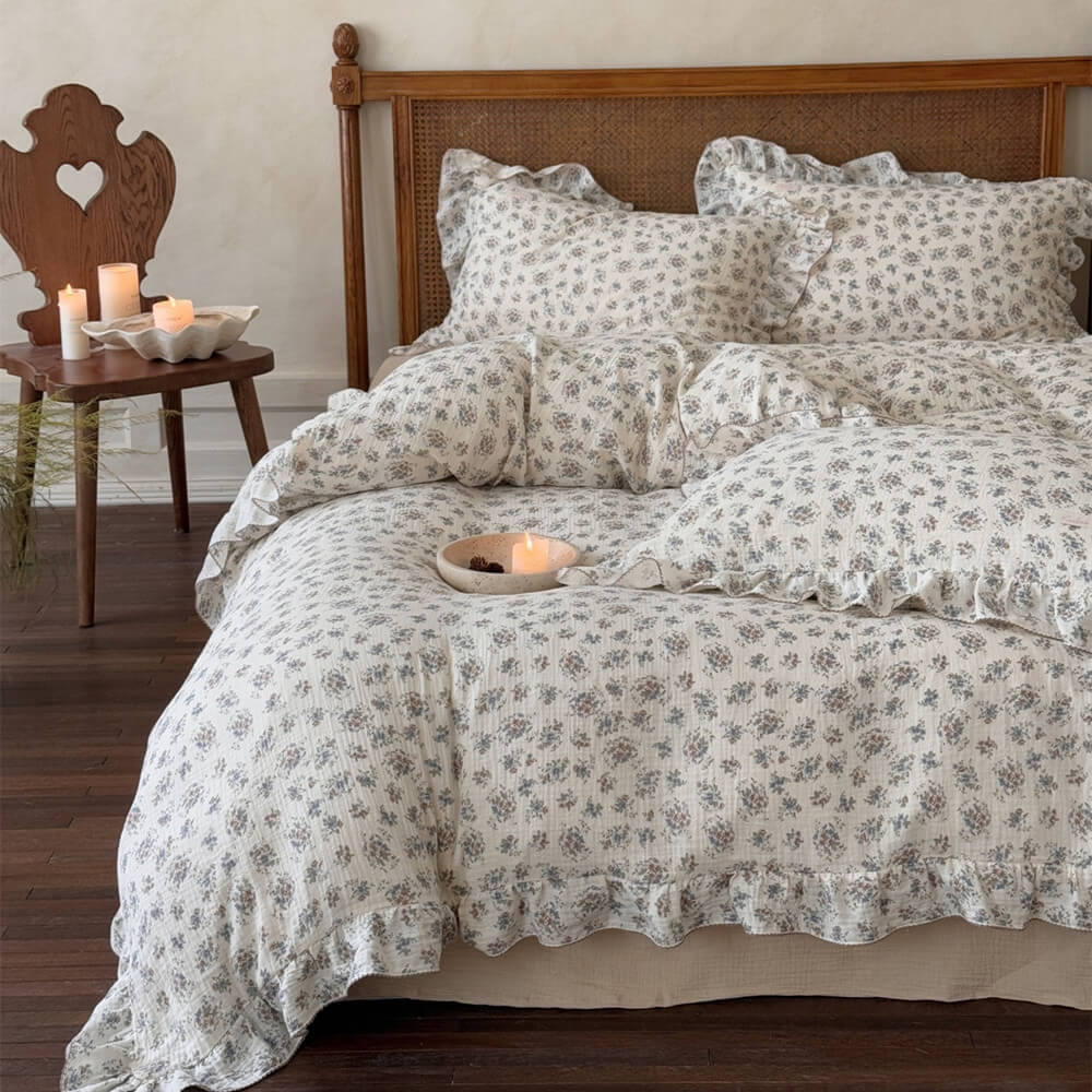Muted floral ruffled duvet cover set with matching pillowcases on an ivory cottage bed