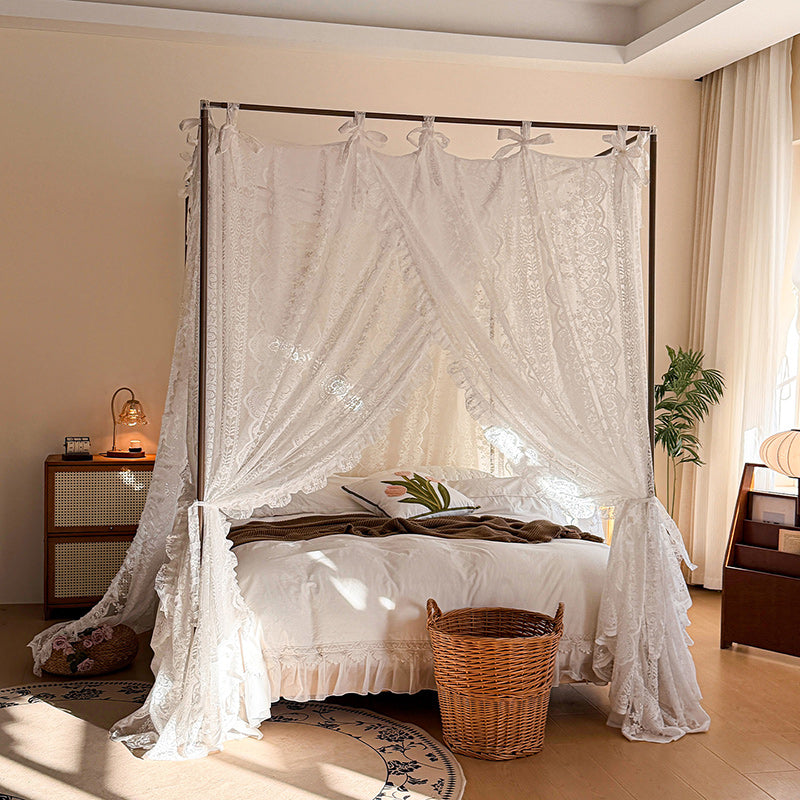 Bedroom with a canopy bed draped in lace curtains, wooden nightstands, and a plant.