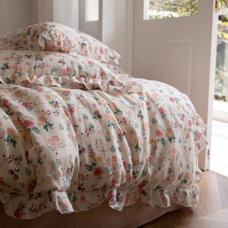 A side view of the floral bunny bedding set on a bed, showing the ruffle trim and the light, airy texture of the cotton gauze fabric.