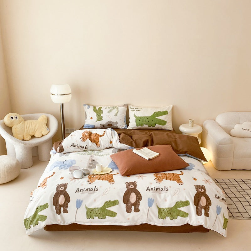 A wide shot of a bed with a white duvet cover decorated with cartoon bears, tigers, and alligators. A solid brown flat sheet is visible underneath