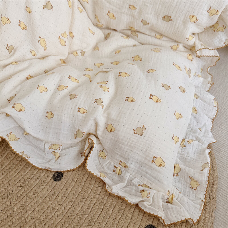 Close-up of soft cotton muslin bedding with duckling pattern and ruffled edge