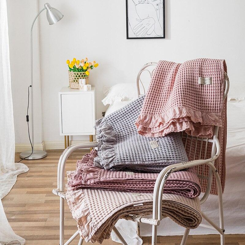 cotton waffle blanket with ruffle edge displayed on a chair